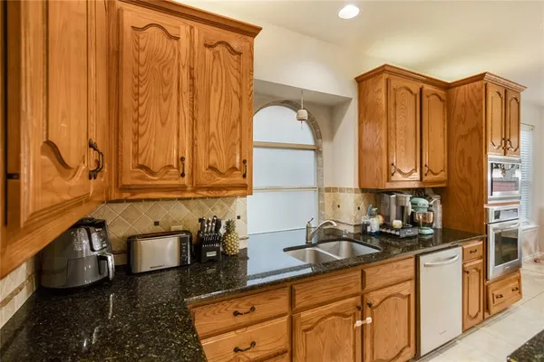 a kitchen with stainless steel appliances granite countertop a sink a stove and a microwave