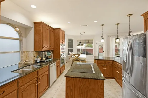 a kitchen with sink refrigerator and cabinets