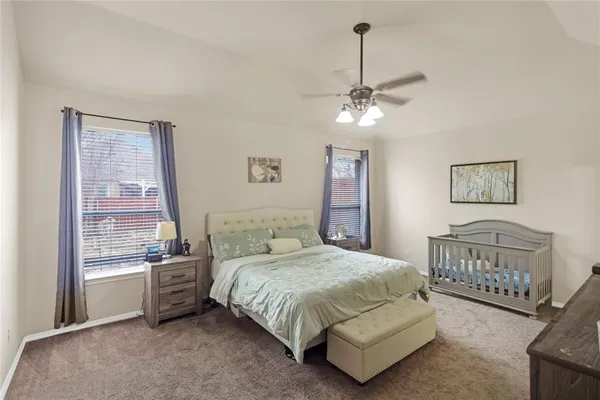 a bedroom with a bed chandelier and a window