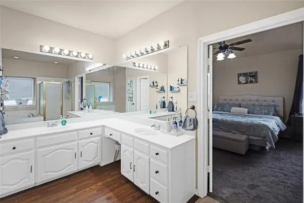 a spacious en suite bathroom with a double vanity sink and mirror