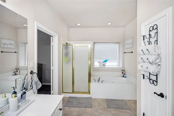 a bathroom with a tub sink and mirror