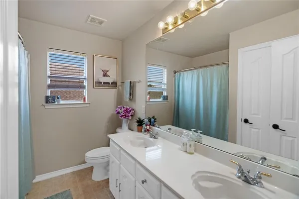 a bathroom with a sink vanity granite and toilet