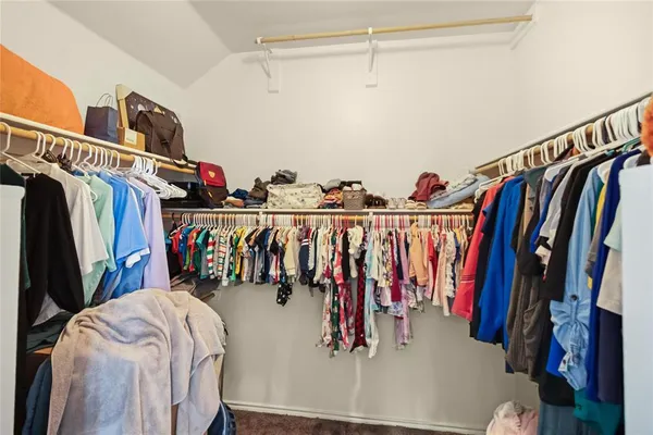 a view of walk in closet with clothes