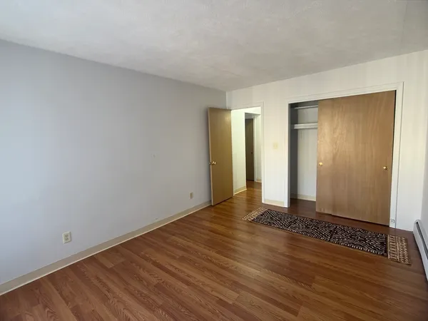 a view of an empty room with wooden floor