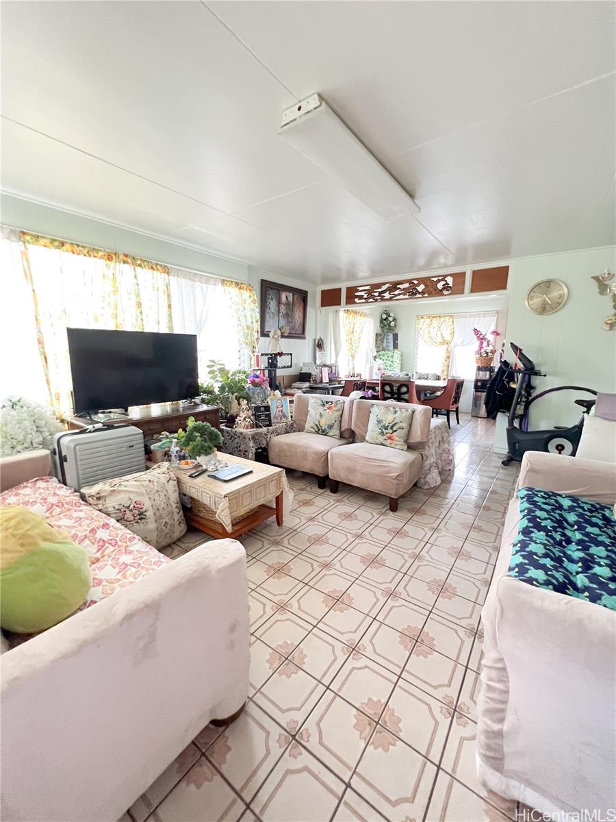 1815 Eluwene Street Honolulu, HI 96819 - Photo 2 of 11 a living room with furniture and a flat screen tv