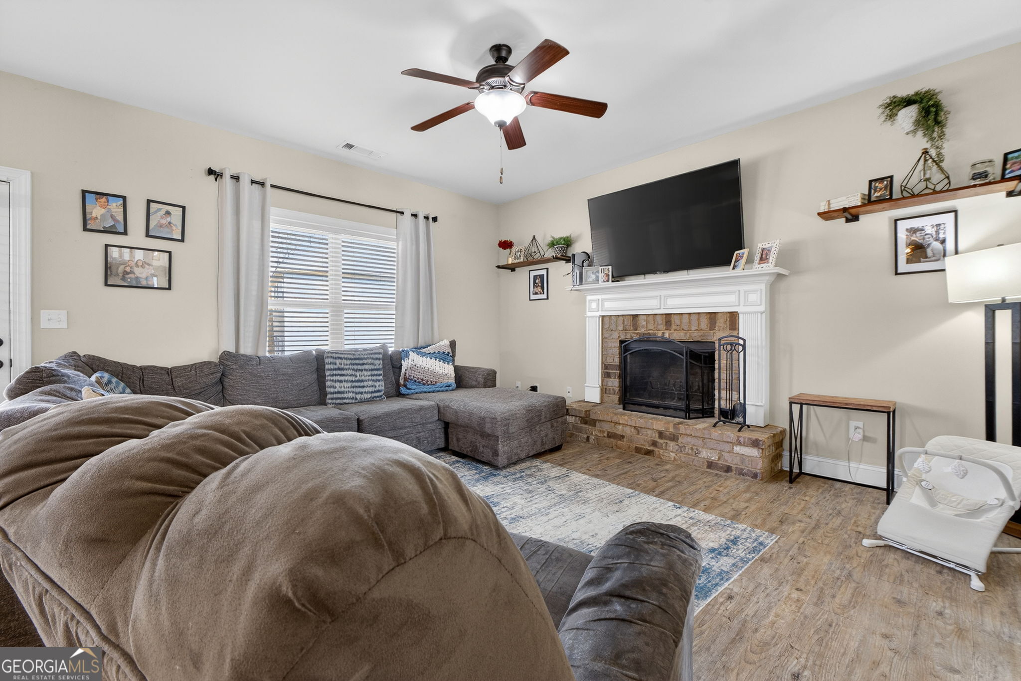 482 Louise Way Locust Grove, GA 30248 - Photo 6 of 29 a living room with furniture a flat screen tv and a fireplace