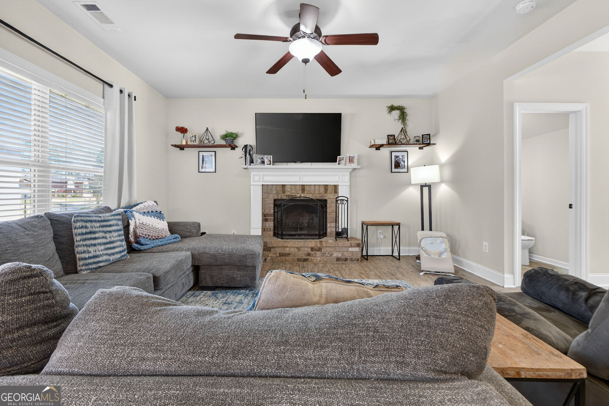 482 Louise Way Locust Grove, GA 30248 - Photo 7 of 29 a living room with furniture a flat screen tv and a fireplace