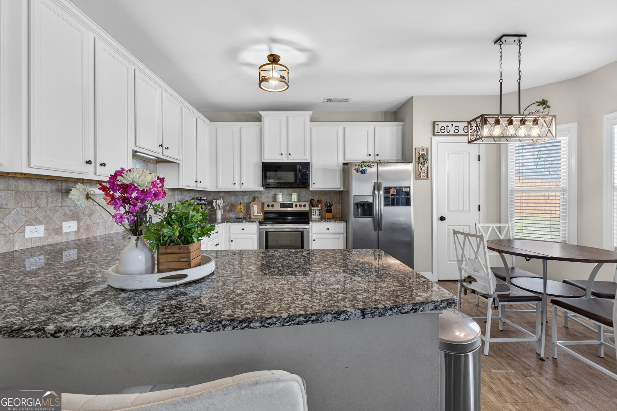 482 Louise Way Locust Grove, GA 30248 - Photo 8 of 29 a kitchen with stainless steel appliances granite countertop a sink refrigerator and microwave