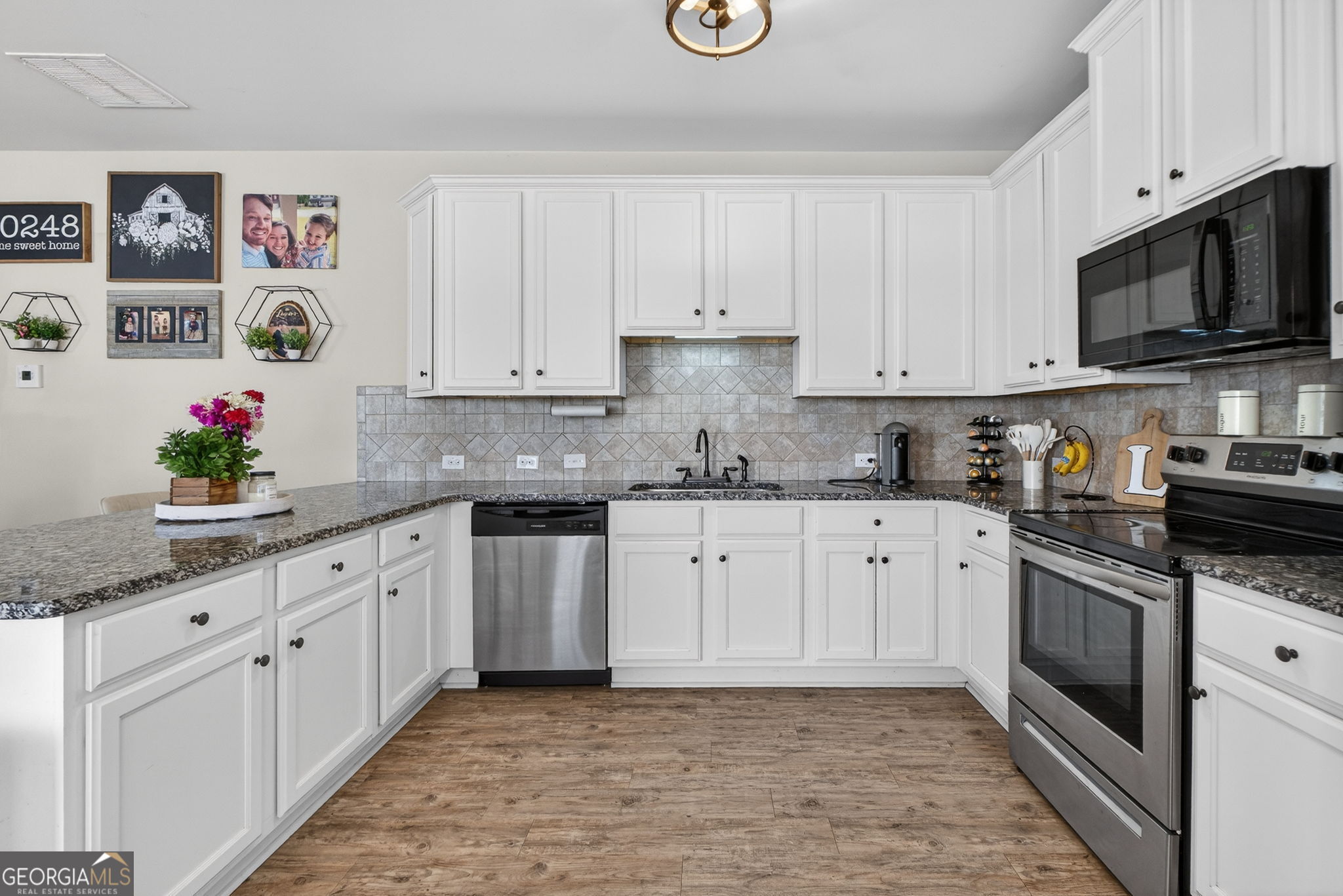 482 Louise Way Locust Grove, GA 30248 - Photo 10 of 29 a kitchen with granite countertop white cabinets stainless steel appliances and a sink