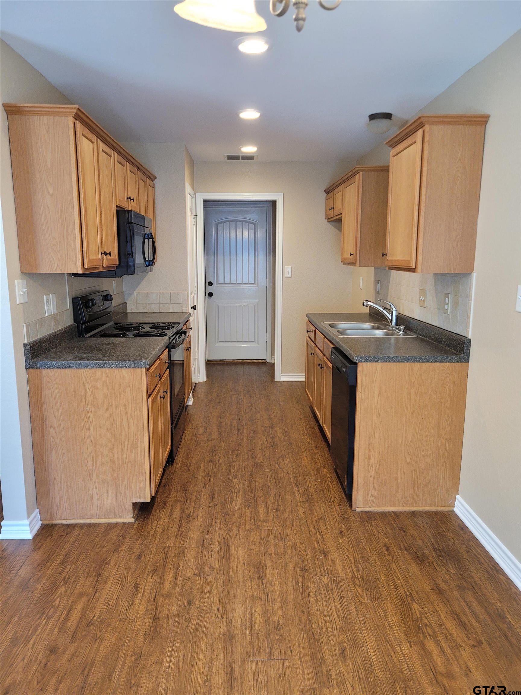 19054 County Road 1202 Flint, TX 75762 - Photo 7 of 19 a kitchen with stainless steel appliances granite countertop a stove a sink a refrigerator white cabinets and wooden floor