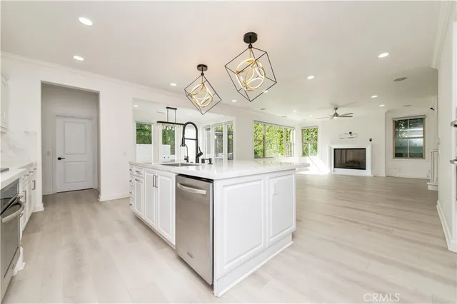 a kitchen with white cabinets and sink