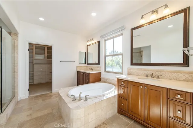 a bathroom with a tub a sink and a large mirror