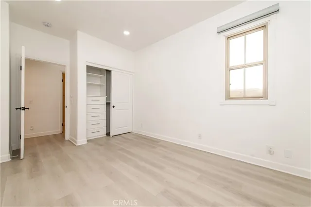 an empty room with closet and windows