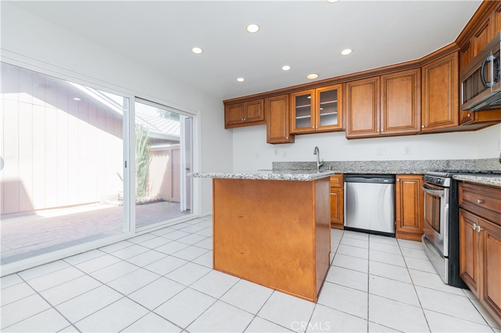 498 Monroe, Unit 15 Irvine, CA 92620 - Photo 7 of 26 a kitchen with stainless steel appliances granite countertop a stove and a sink