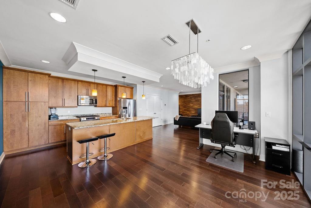 a living room with furniture kitchen view and a chandelier