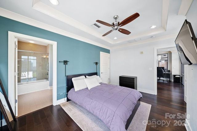 a bedroom with a large bed and a chandelier