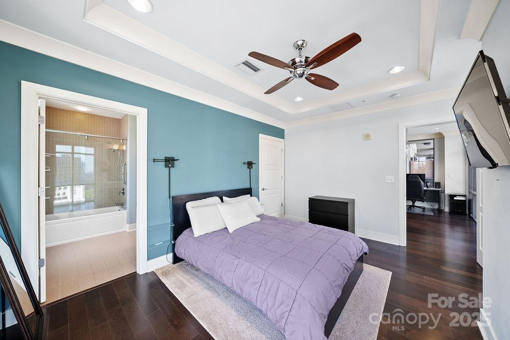 222 South Caldwell Street, Unit 1509 Charlotte, NC 28202 - Photo 12 of 27 a bedroom with a large bed and a chandelier