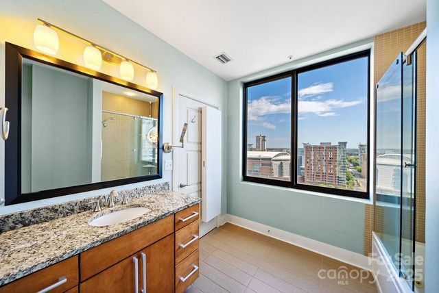 a bathroom with a large window and a double vanity sink