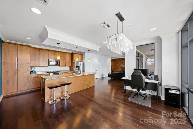 a living room with furniture kitchen view and a chandelier