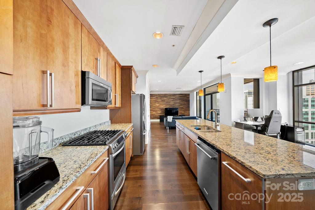 222 South Caldwell Street, Unit 1509 Charlotte, NC 28202 - Photo 8 of 27 a large kitchen with stainless steel appliances granite countertop a stove and a sink
