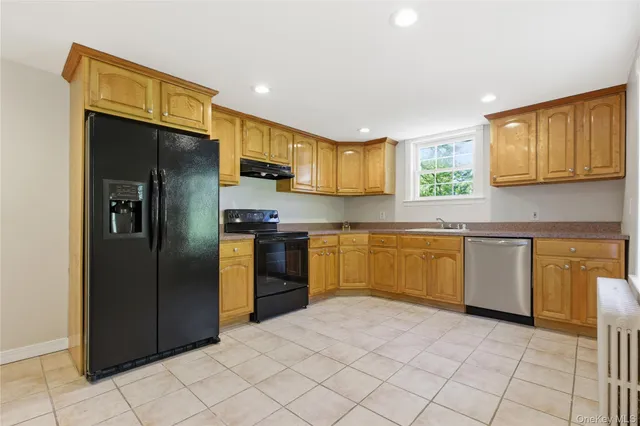 a kitchen with stainless steel appliances granite countertop a refrigerator and a stove top oven