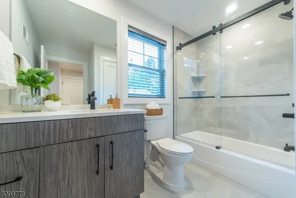 a bathroom with a granite countertop sink a toilet and shower