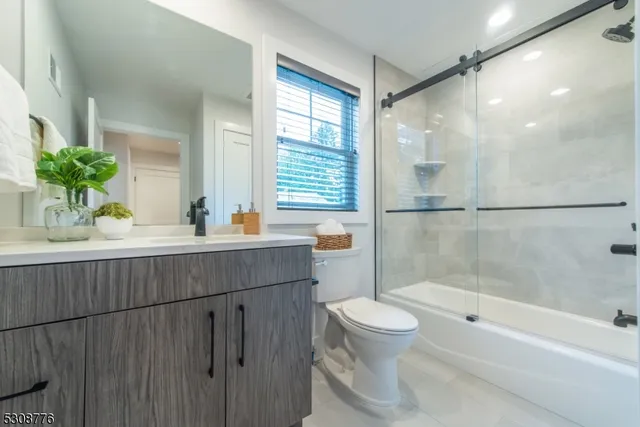 a bathroom with a granite countertop sink a toilet and shower