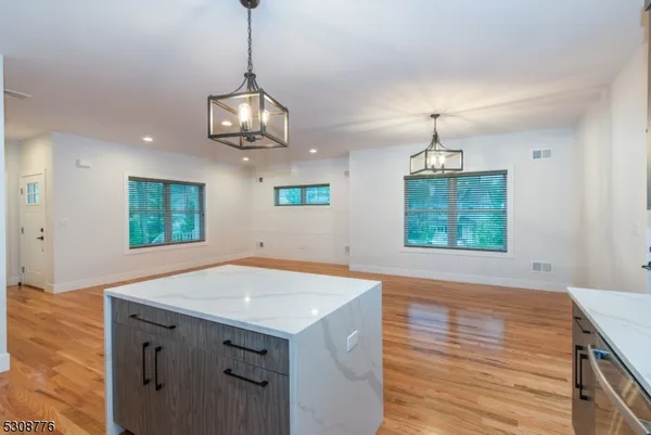 a view of an empty room with window wooden floor and chandelier