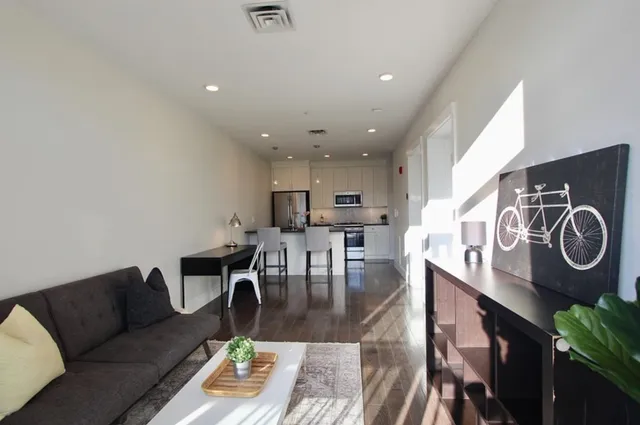 a living room with lots of furniture and kitchen view