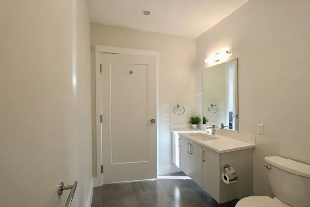a bathroom with a sink a toilet and mirror