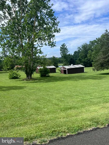 a view of a green field with wooden fence