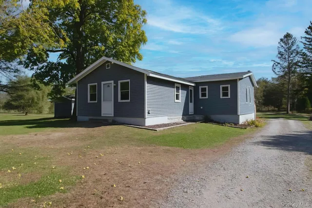 a front view of house with yard and trees