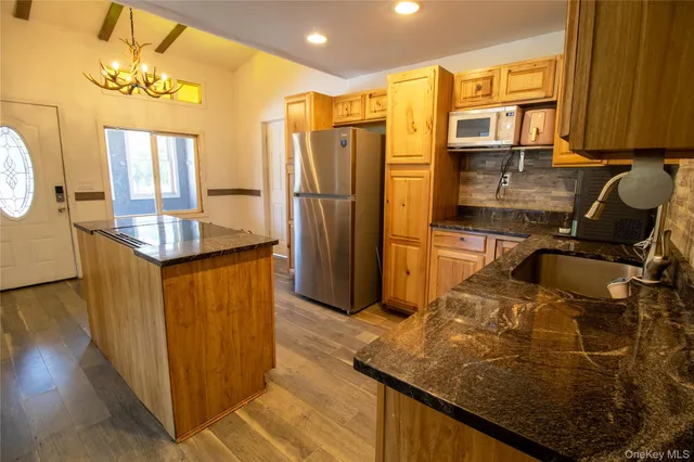 a kitchen with stainless steel appliances granite countertop a sink refrigerator and cabinets