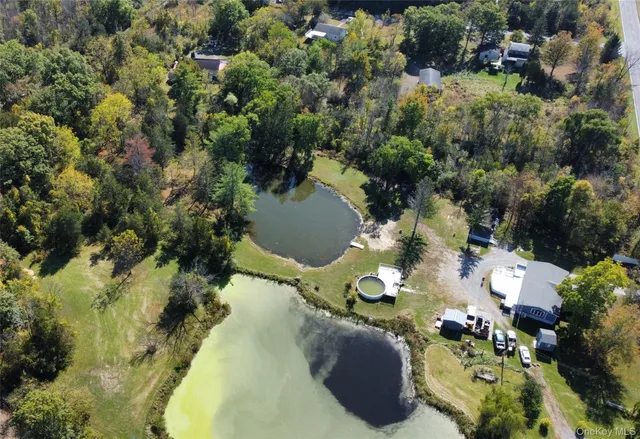 an aerial view of residential house with green space and fog