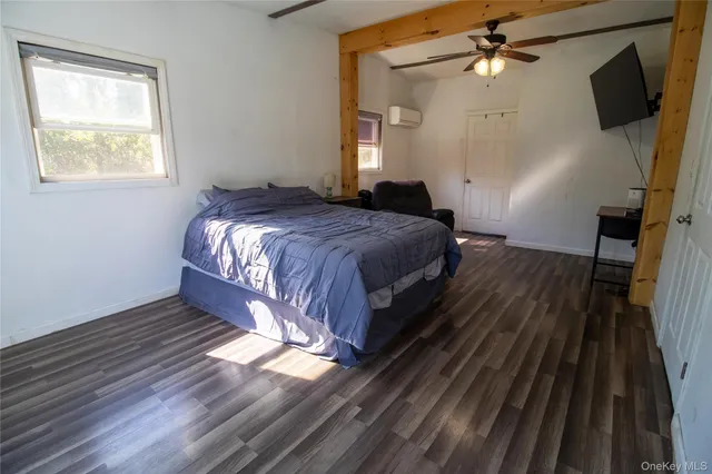 a spacious bedroom with a bed and wooden floor