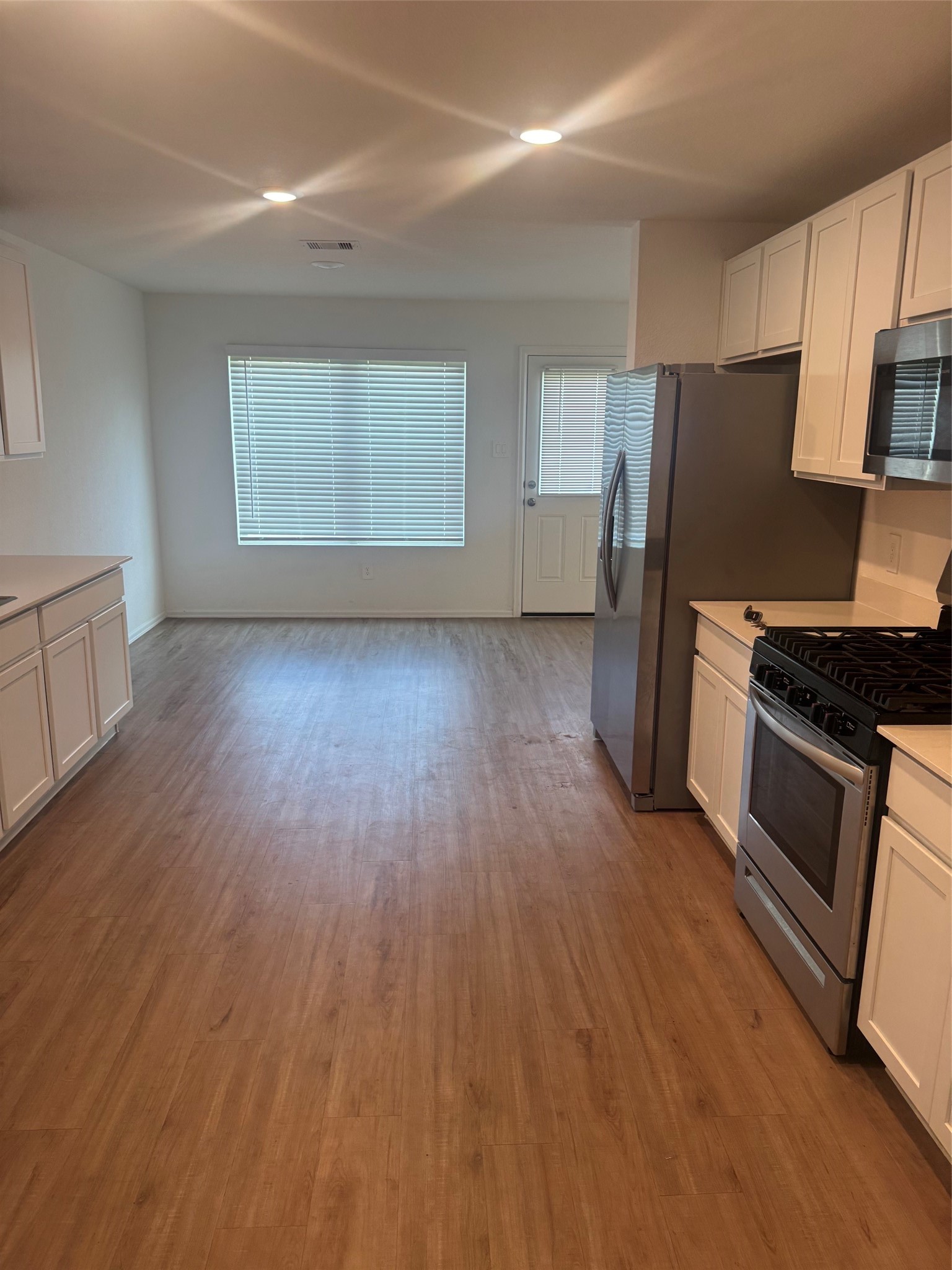 3202 Holly Stokes Way Conroe, TX 77301 - Photo 6 of 24 a kitchen with wooden floors and appliances