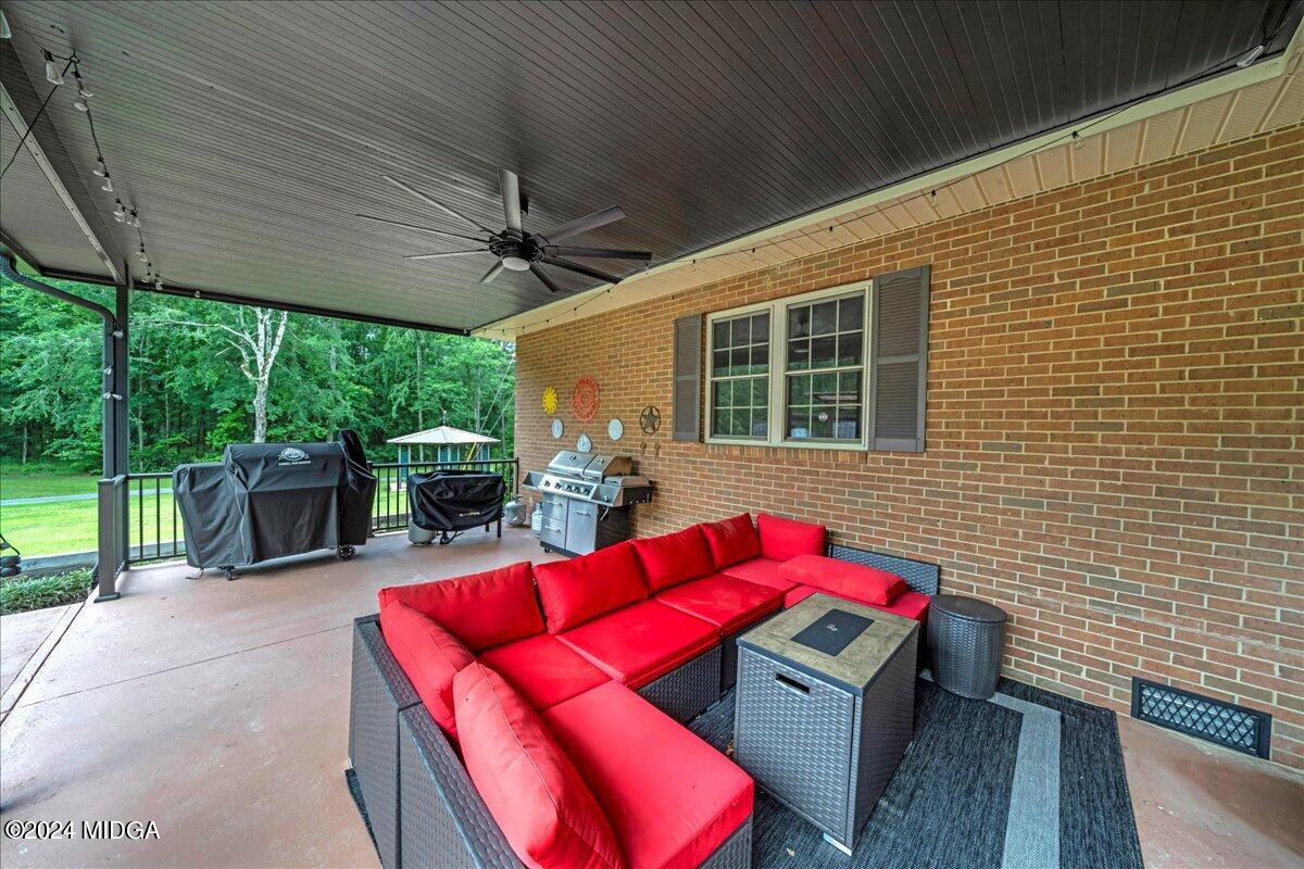 474 Plantation Road Gray, GA 31032 - Photo 27 of 64 a view of a patio with table and chairs potted plants with wooden floor and floor to ceiling window