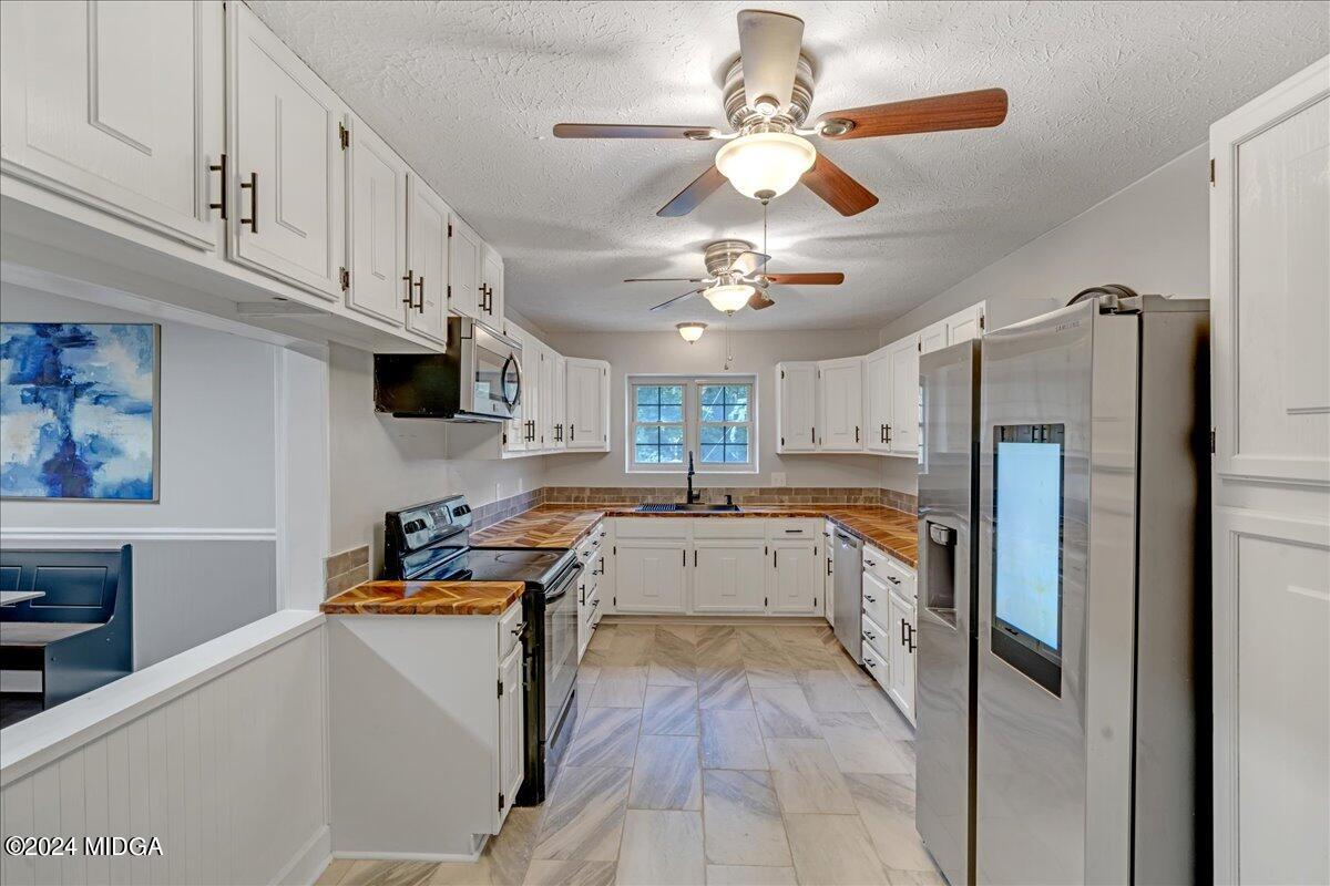 474 Plantation Road Gray, GA 31032 - Photo 34 of 64 a kitchen with stainless steel appliances granite countertop a refrigerator a stove a sink dishwasher and a refrigerator with wooden floor