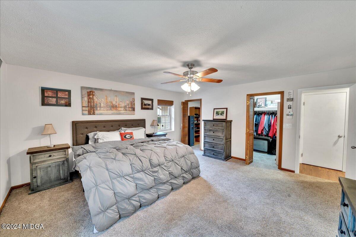 474 Plantation Road Gray, GA 31032 - Photo 38 of 64 a bedroom with a large bed and a chandelier