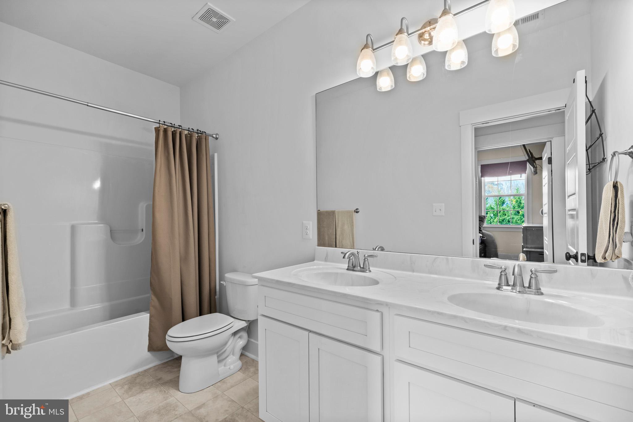 1965 Lowery Road Huntingtown, MD 20639 - Photo 39 of 54 a bathroom with a sink a toilet and a large mirror