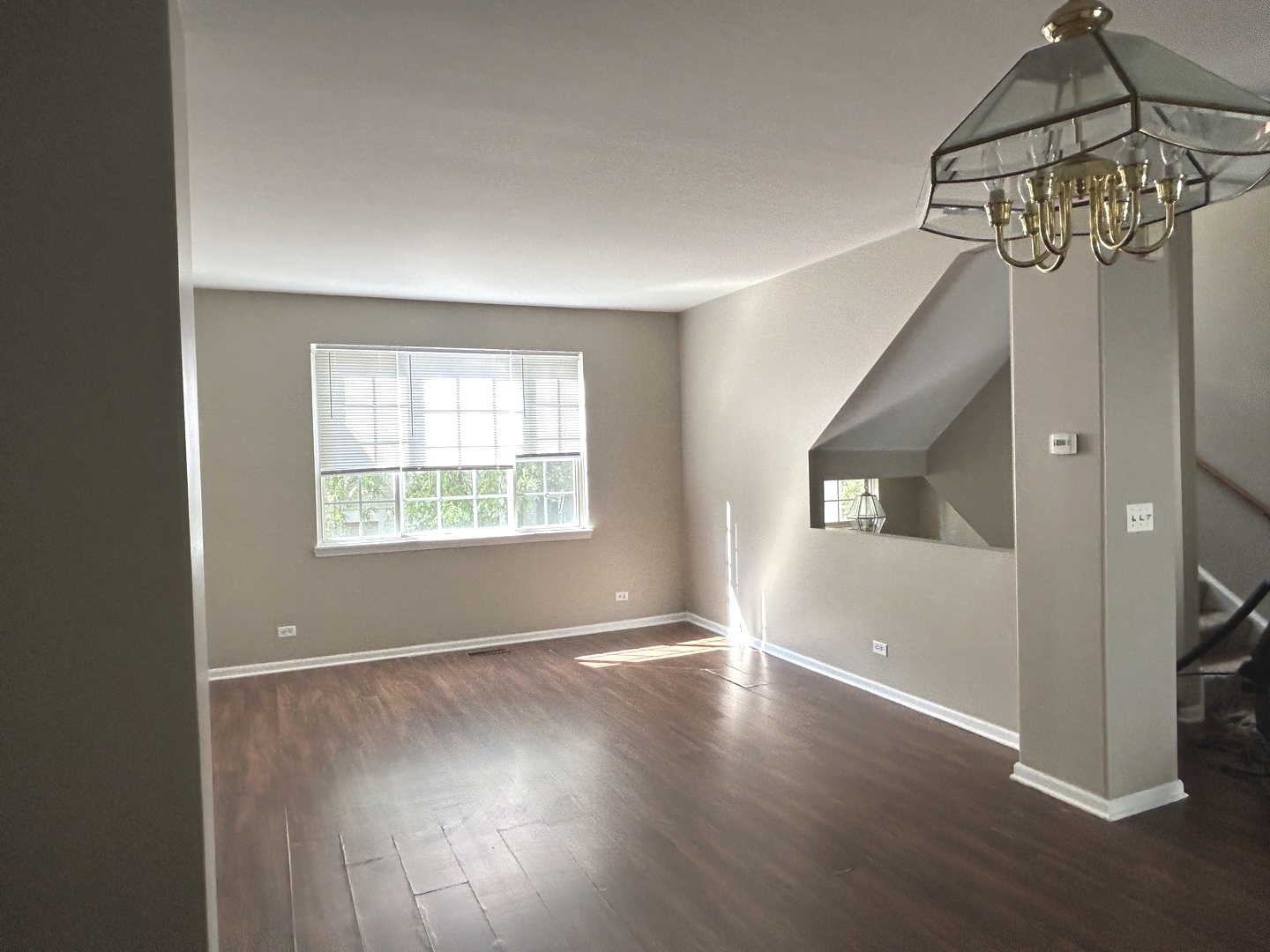 3466 Ravinia Circle, Unit 3466 Aurora, IL 60504 - Photo 6 of 24 an empty room with wooden floor chandelier and windows