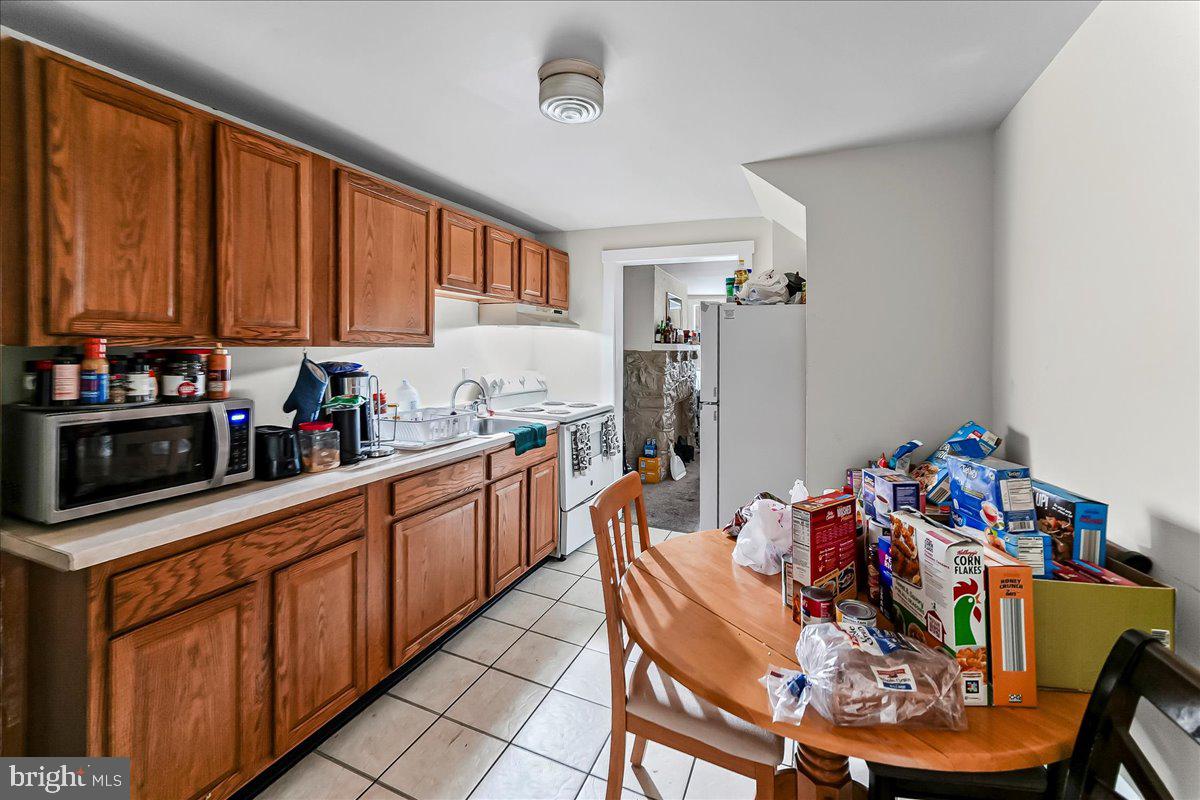 162 West Main Street Elkton, MD 21921 - Photo 12 of 41 a kitchen with stainless steel appliances kitchen island granite countertop a dining table chairs a refrigerator and a sink
