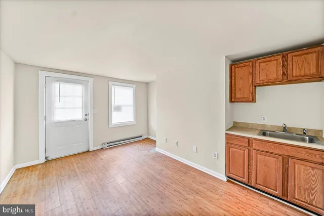 a view of a kitchen with wooden floor and electronic appliances