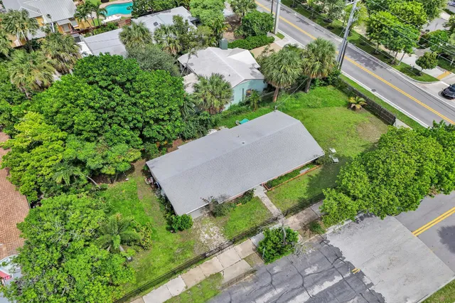 a view of a house with a yard and potted plants