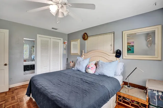 a bedroom with a bed and a chandelier fan