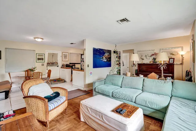 a living room with furniture kitchen view and a table