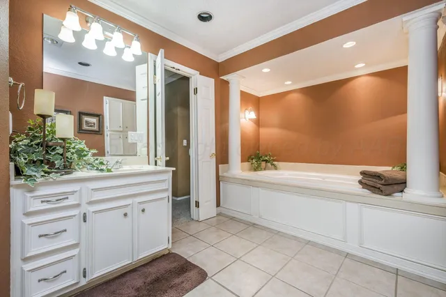 a bathroom with a tub sink and mirror