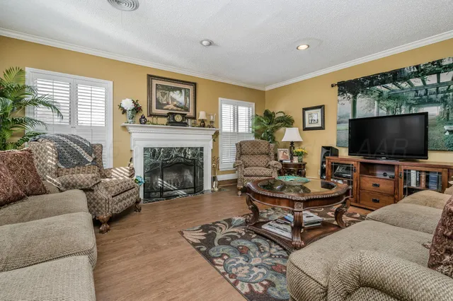a living room with furniture a flat screen tv and a fireplace