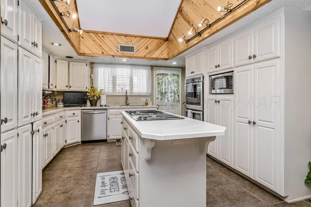 a kitchen with white cabinets and white appliances