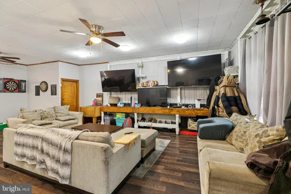 a living room with furniture a flat screen tv and a table